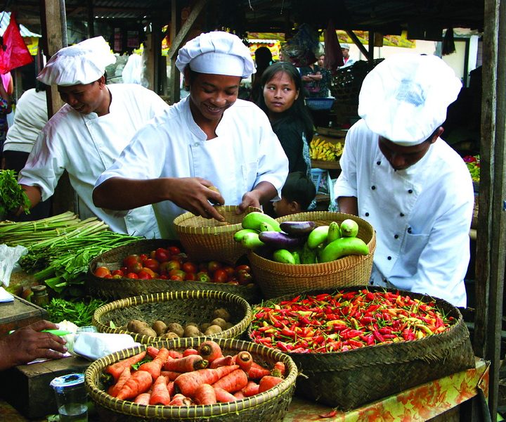 Auf einem bunten Markt auf Bali in Indonesien wird frisches Obst und Gemüse verkauft.