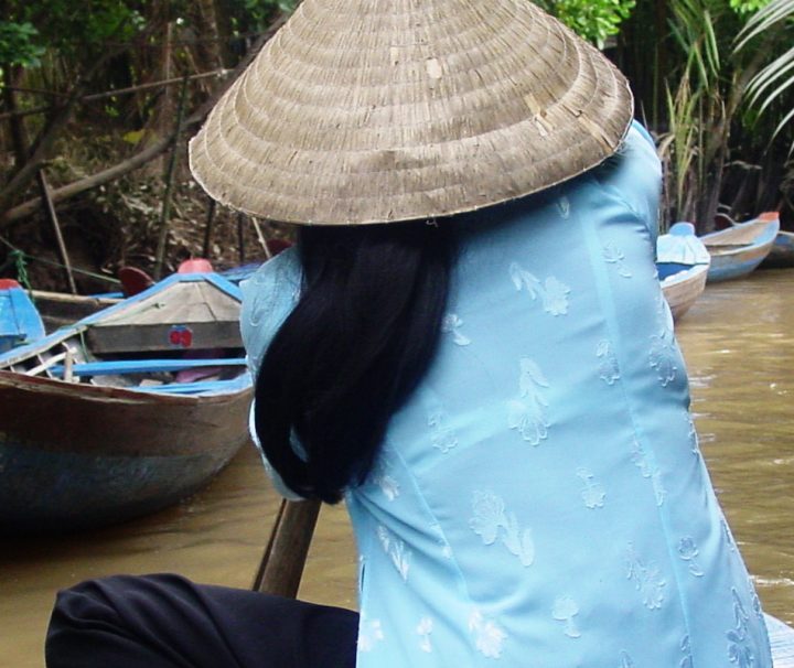 Einheimische Frau bei einer Fahrt auf einem kleinen Seitenarm des Mekongs, Erleben Sie den Mekong auf unserem Vietnam Rundreisen