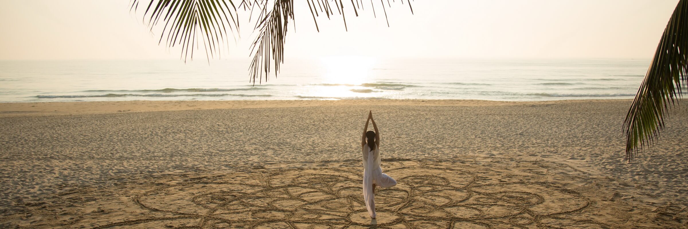 Yogaübungen am Hotelstrand im Fusion Maia Danang Resort mit Panoramablick auf das Meer, eine entspannte Weise den Vietnam Urlaub zu gestalten.ramablick auf das Meer