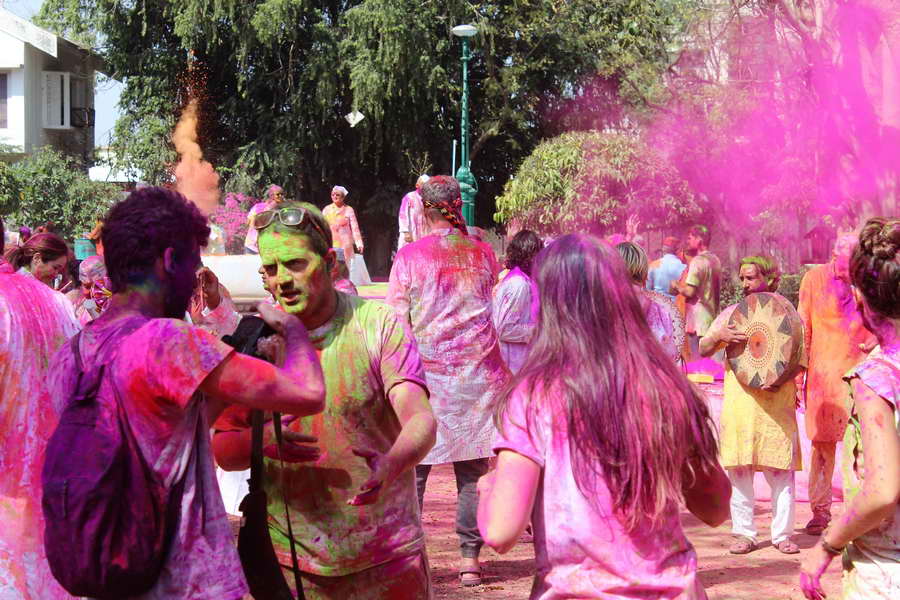 Klassisches Bild während des Holi Festes in Indien: bunte Menschen und Farbe die durch die Luft fliegt